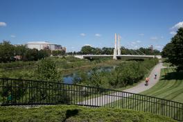 Bike path through OSU campus; green grass with path going through with bikers riding bicycles